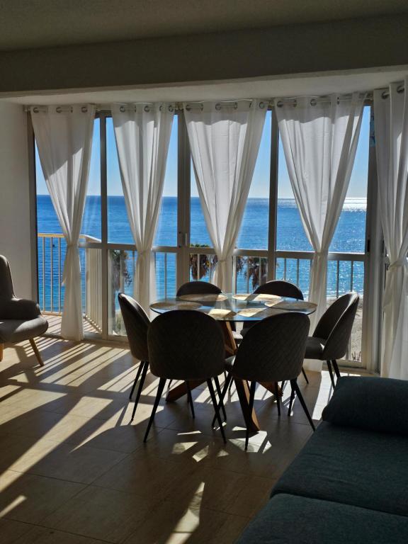a dining room with a table and chairs and the ocean at Horizonte Azul in Calpe
