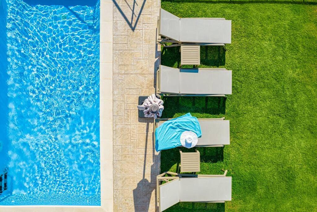 uma vista superior de uma piscina com um guarda-chuva azul em Apartment Lia with private eco pool - Amazing view em Chania Town