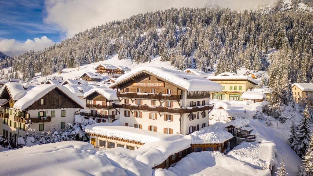 un complexe dans les montagnes couvertes de neige dans l'établissement Wellness Hotel Bladen, à Sappada