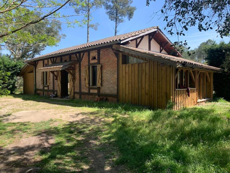 a small house in a field next to a yard at Maison Typique Landaise in Moliets-et-Maa