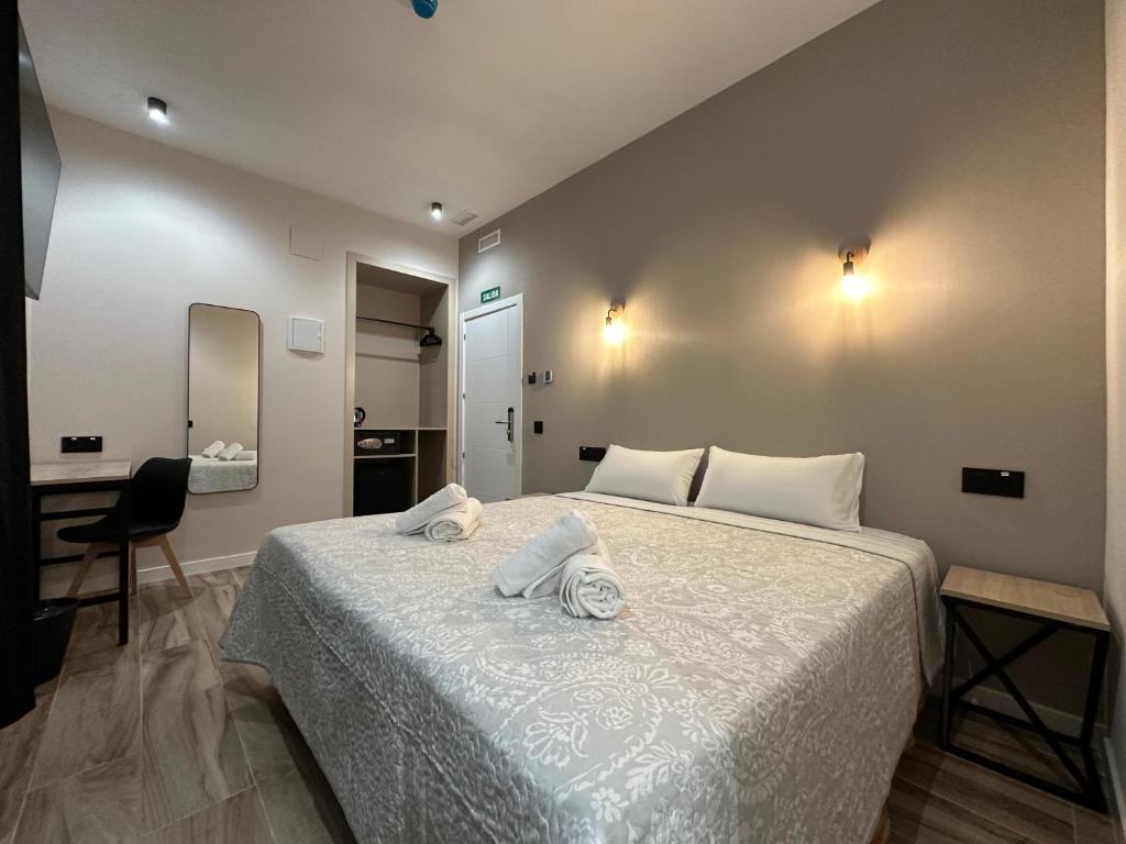 a bedroom with a bed with towels on it at CC Opera Suites in Madrid