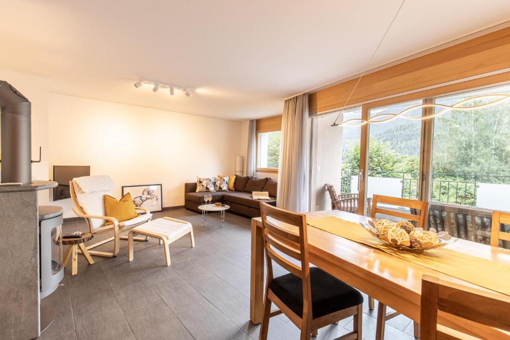 a kitchen and living room with a table and chairs at La Stüvetta in Scuol