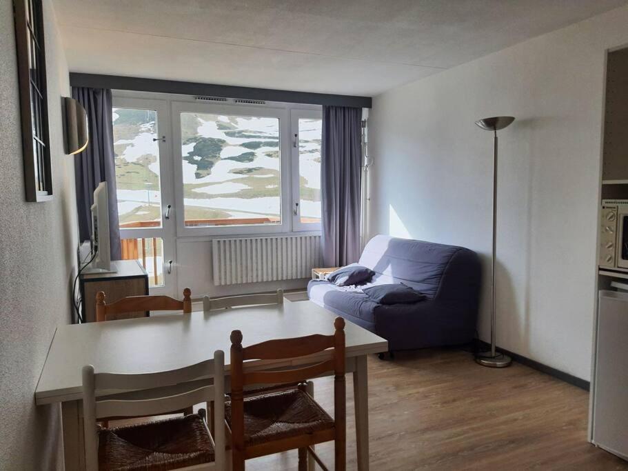un salon avec un canapé bleu et une table dans l'établissement Joli T2 au pied des pistes, parking couvert, wifi, à La Mongie