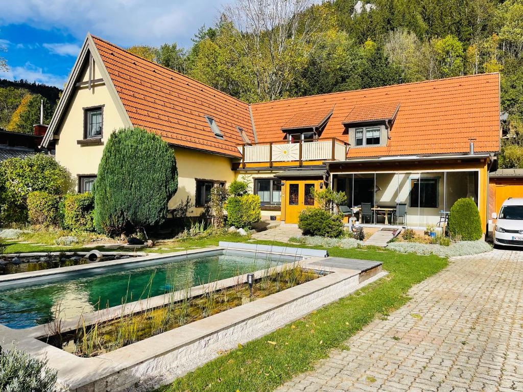 a house with a swimming pool in front of a house at Ferienwohnung Sonnleiten in Puchberg am Schneeberg