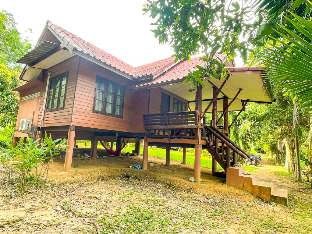 a wooden house with a porch and a deck at Koh Yao Noi Garden Home in Ban Nai Khlong