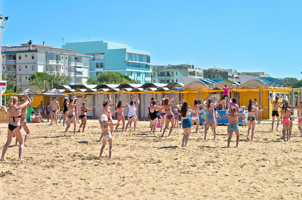 a group of people in bathing suits on a beach at Hotel Montecarlo in Bibione