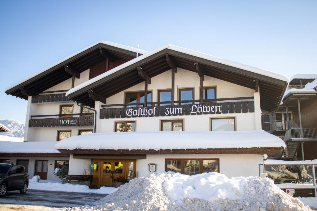 a building with a snow pile in front of it at Hotel Löwen in Lingenau