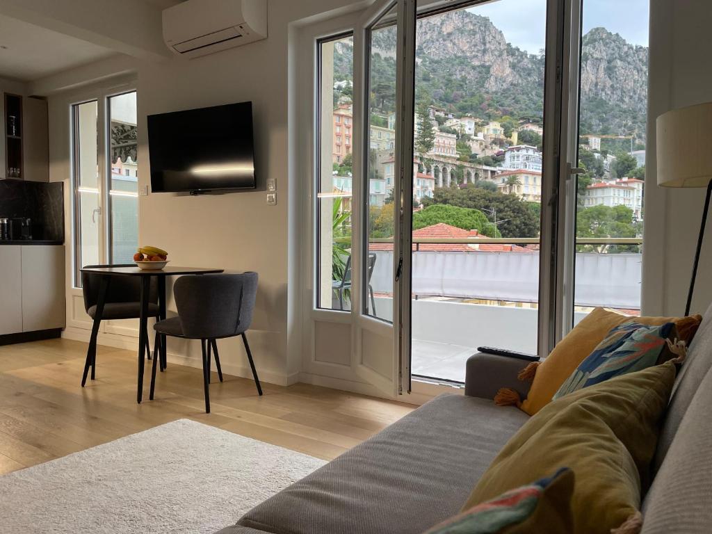 ein Wohnzimmer mit einem Sofa und einem Tisch in der Unterkunft Luxury Top Floor Apartment with terrace - Beaulieu Sur Mer in Beaulieu-sur-Mer