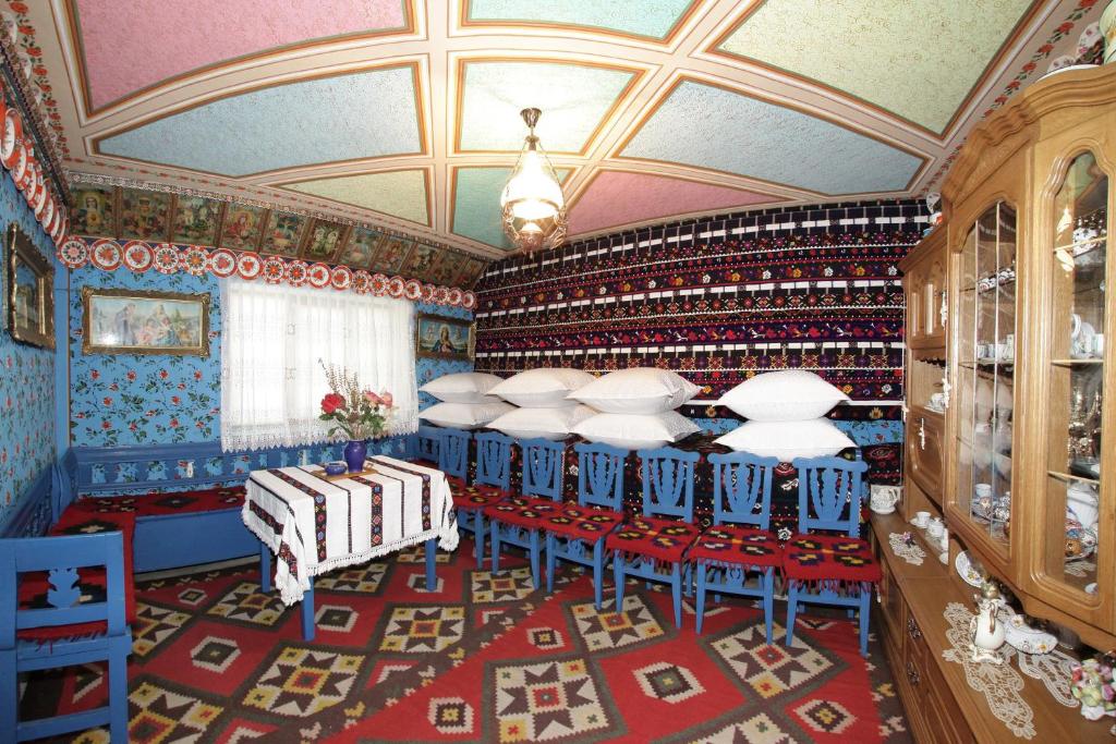 a dining room with blue chairs and a ceiling at ILEANA Săpânța in Săpânța