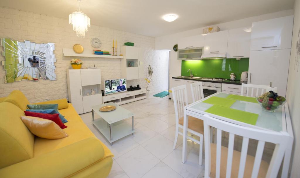 uma cozinha e sala de estar com um sofá e uma mesa em Apartment Dea em Split