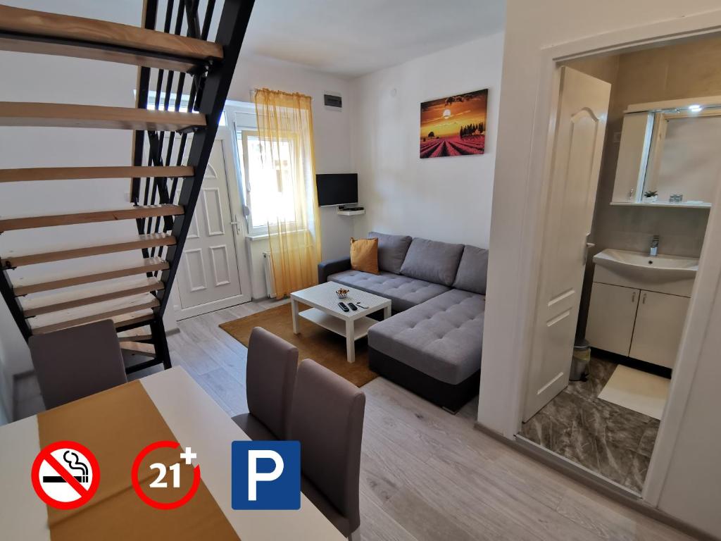 ein Wohnzimmer mit einem Sofa und einem Tisch in der Unterkunft RIS CENTRAL Apartments in Novi Sad