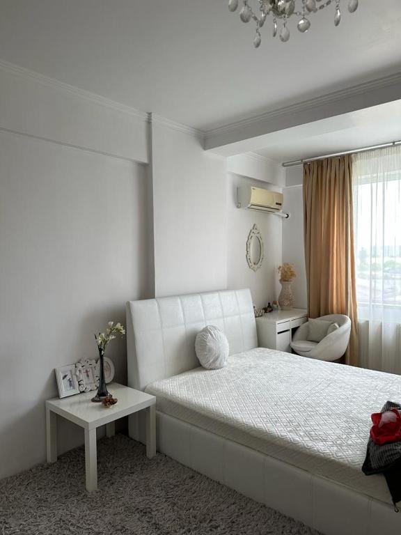 - une chambre blanche avec un lit et une fenêtre dans l'établissement RomExpo Studio, à Bucarest
