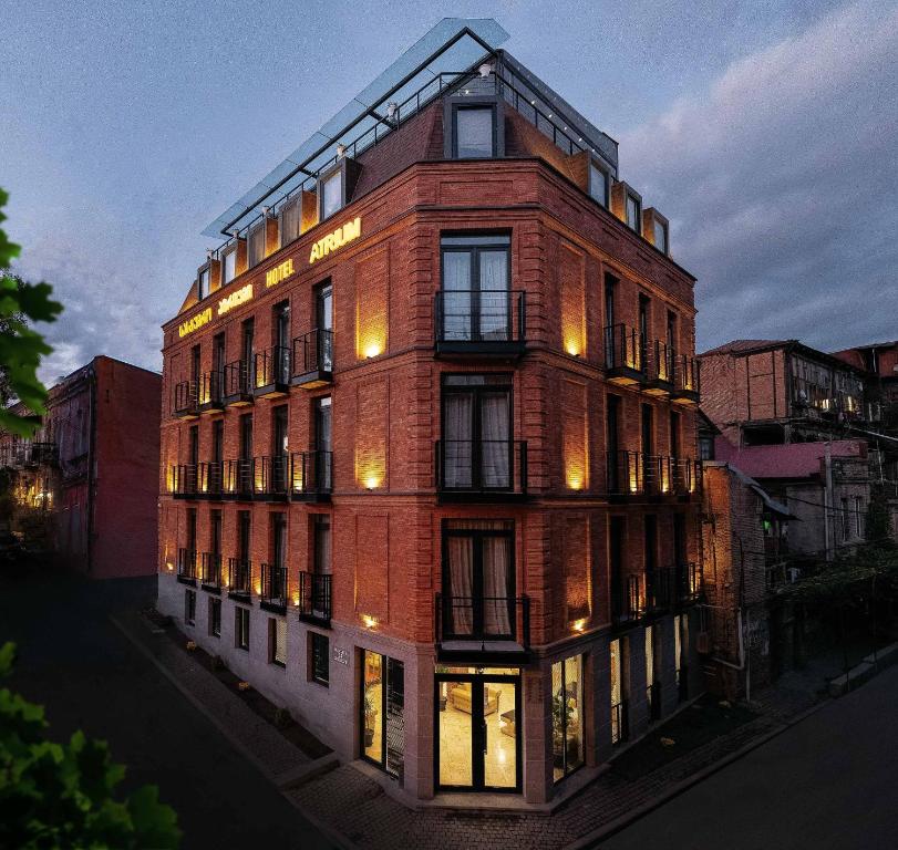 a tall brick building with lights on at Atrium Boutique Hotel in Tbilisi City