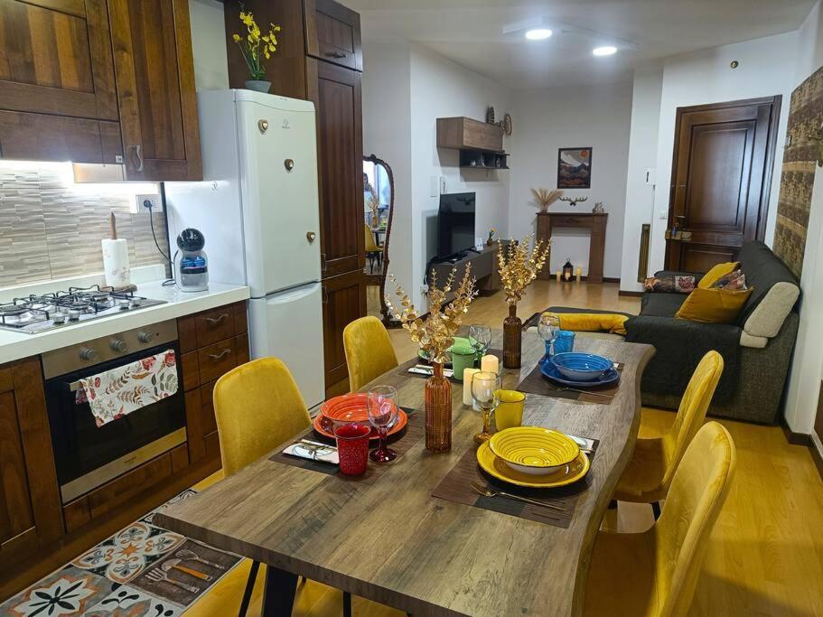 cocina con mesa de madera y sillas amarillas en Happy Guest Apartments - Central Living Borno, en Borno