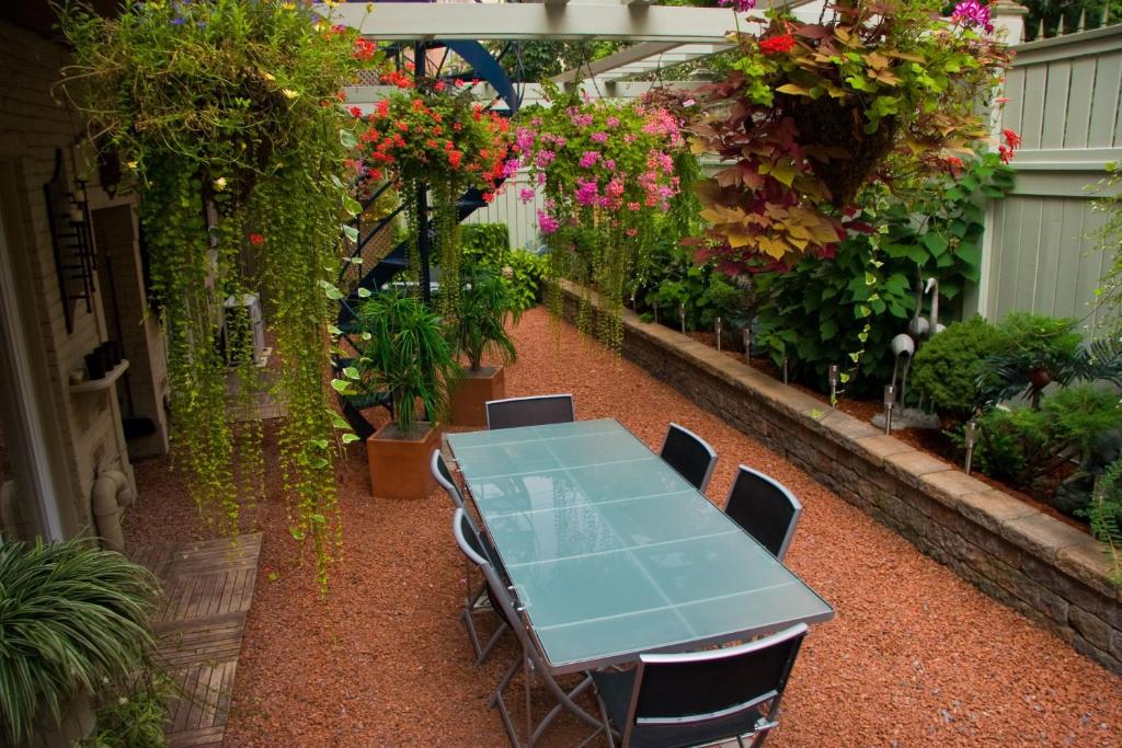 a table and chairs in a greenhouse with flowers at Le Cartier Bed and Breakfast in Montréal