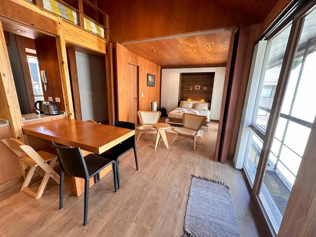 una habitación con mesa y sillas y un dormitorio en Hermoso 2 ambientes, céntrico, 4 pax, muy cálido y cómodo 18V4 en San Martín de los Andes