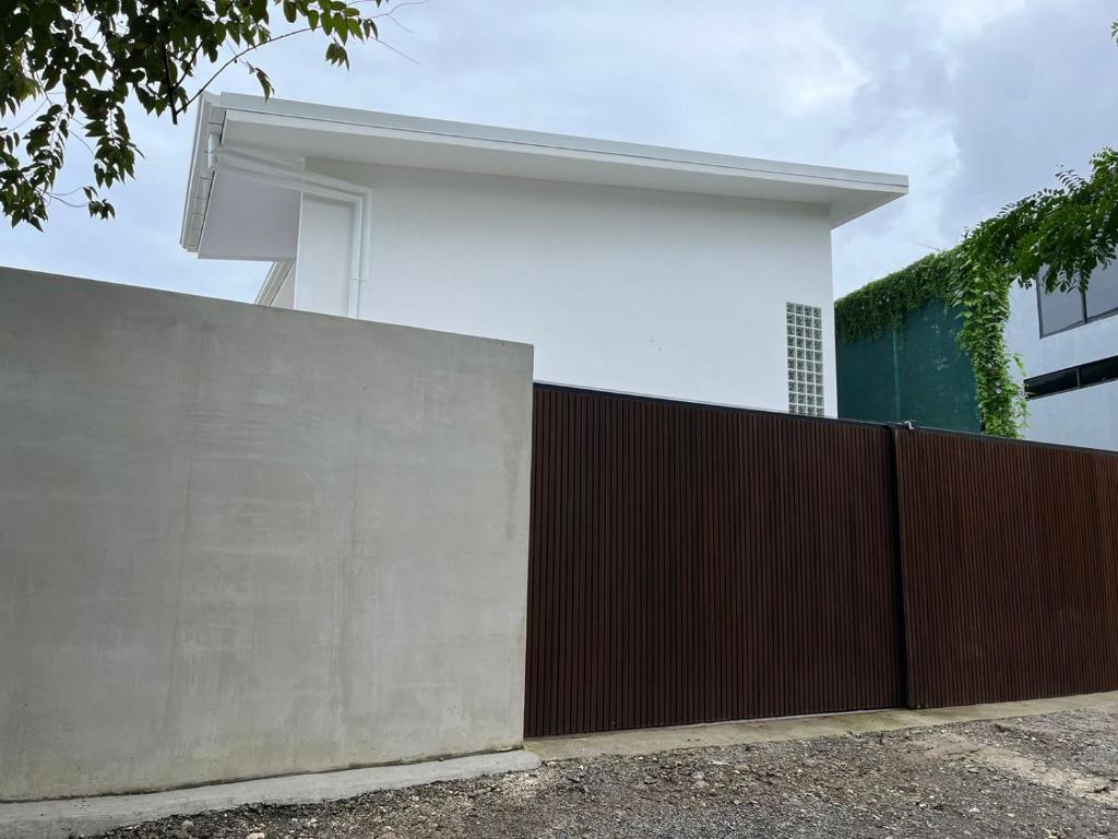 a white house behind a fence with a brown fence at Solemar 2bdrm House - Private Pool , King Bed and Balcony Sunset View in Mal País
