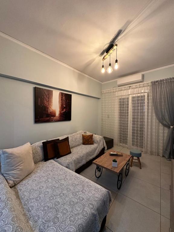 ein Wohnzimmer mit einem Sofa und einem Tisch in der Unterkunft Mairas Ηouse in Piräus