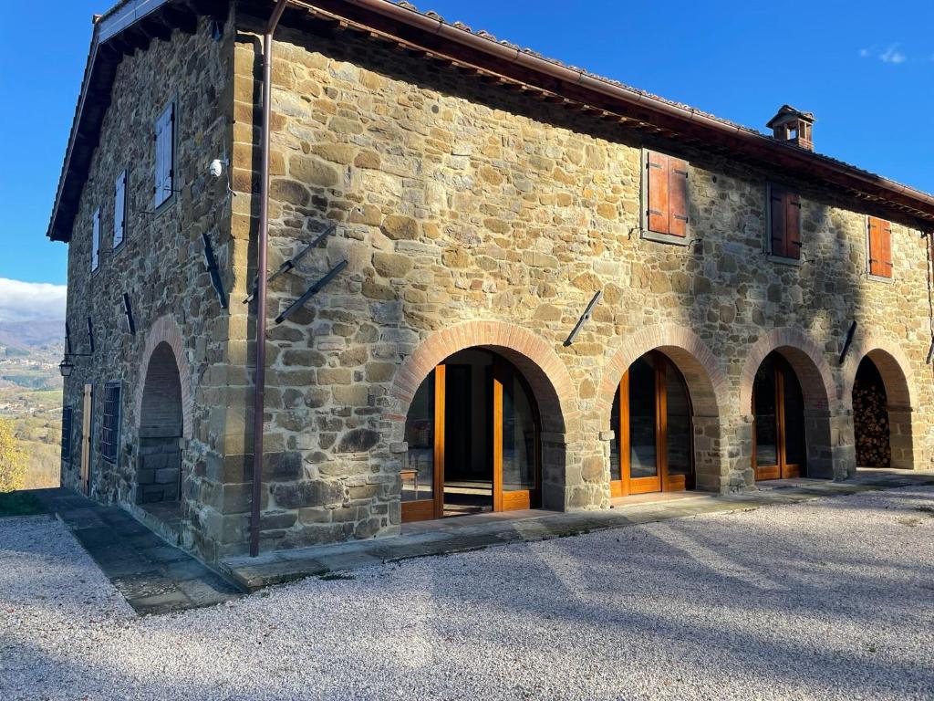 un grande edificio in pietra con archi di Casale borgo le paline a Borgo alla Collina