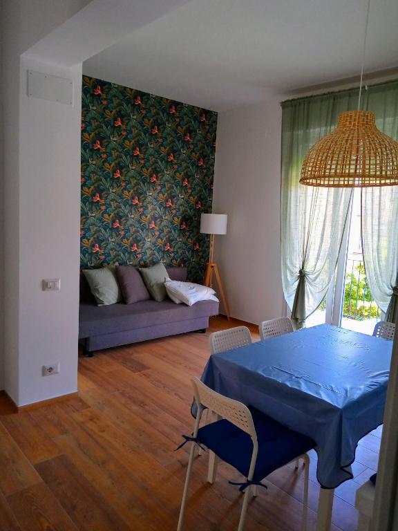 a living room with a blue table and a couch at Trilo Lorenzo - In centro ed a soli 30 m dal mare in Numana
