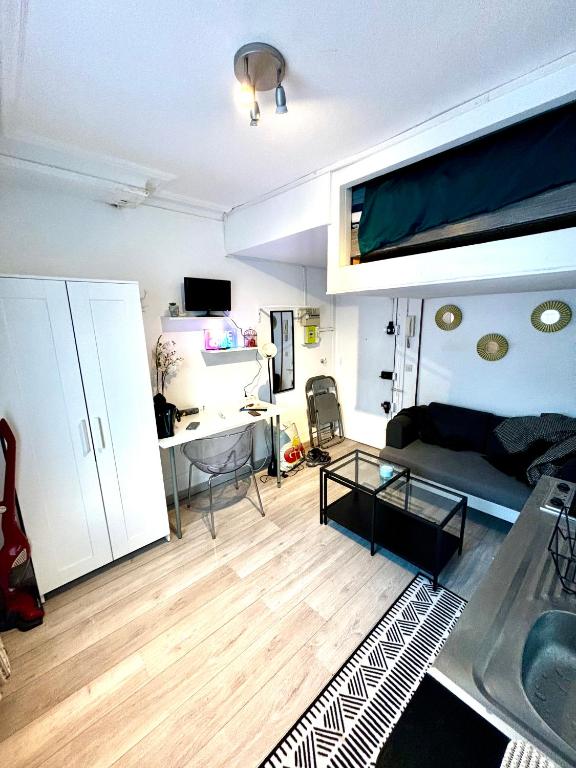 un salon avec un canapé et un bureau dans l'établissement Joli cocon Montmartre, à Paris