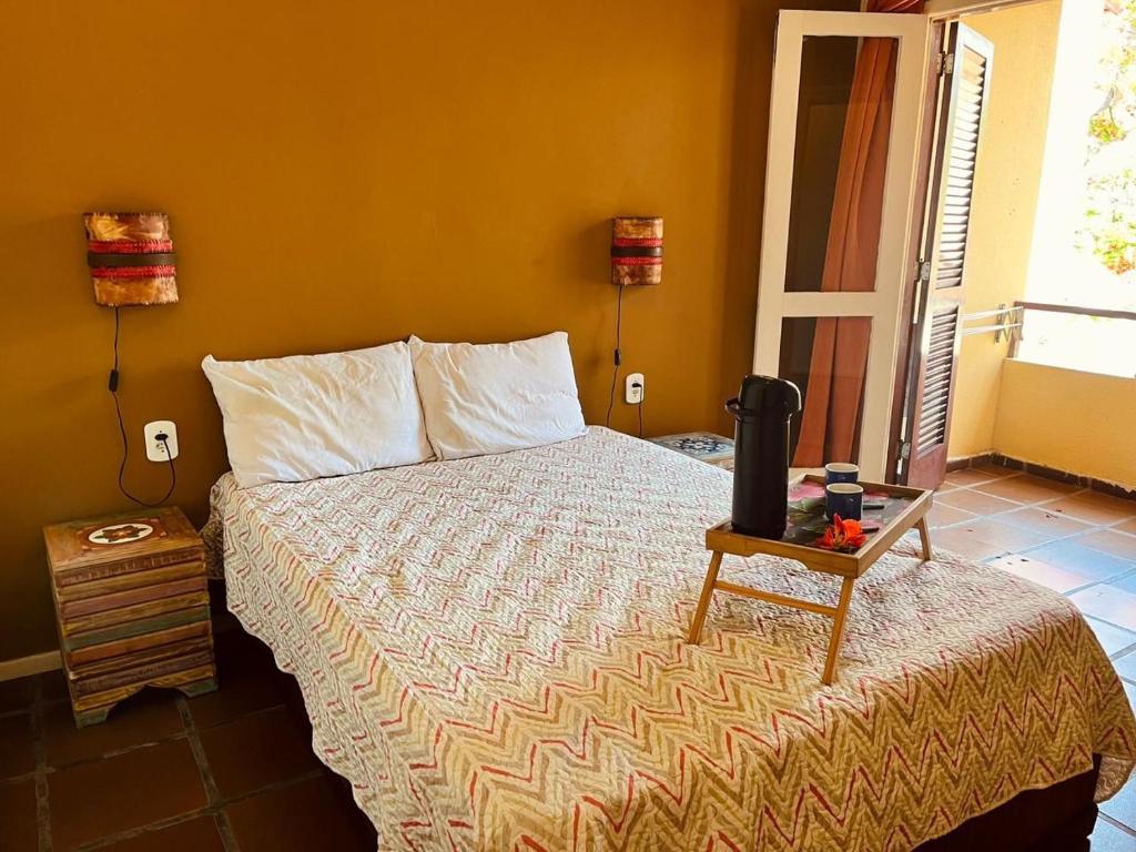 a bedroom with a bed and a table with a tv at Apartamento em Ilha de Cabo Frio in Cabo Frio
