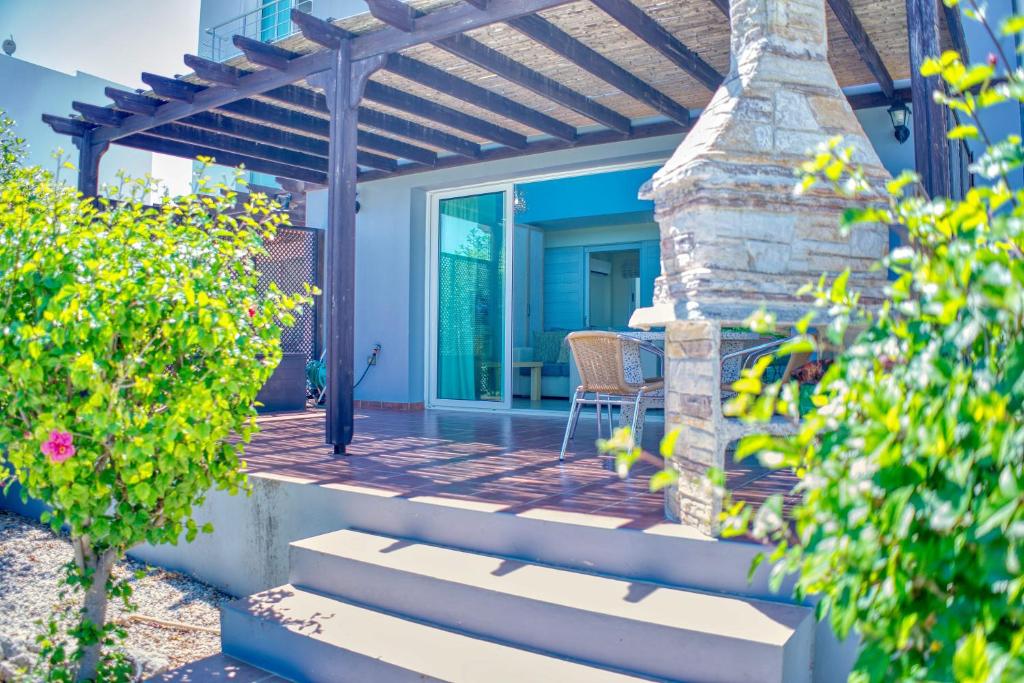 a patio with a table and chairs on a house at Joya Cyprus Sapphire Garden Apartment in Saint Amvrosios