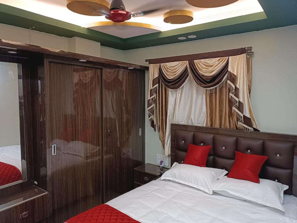 1 dormitorio con cama con almohadas rojas y techo en Alif Serviced (Hotel) Apartments en Tambaram
