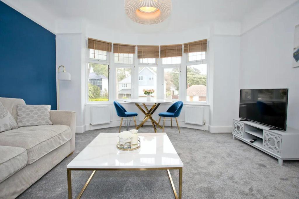 a living room with a couch and a table at A Piece of Seaside Serenity on the Sandbanks Peninsula in Sandbanks