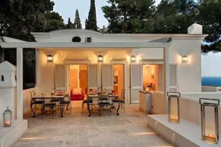 un patio con mesas y sillas en una casa en Villa Bouganvillea Superb Capri Villa with Views en Capri
