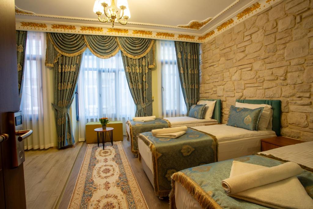 a bedroom with three beds and a stone wall at Sayina Hotel in Istanbul
