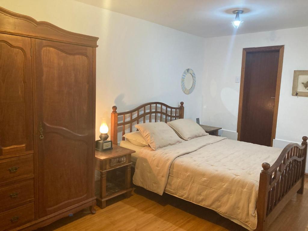 a bedroom with a large bed and a dresser at Loft no Retiro in Brumadinho