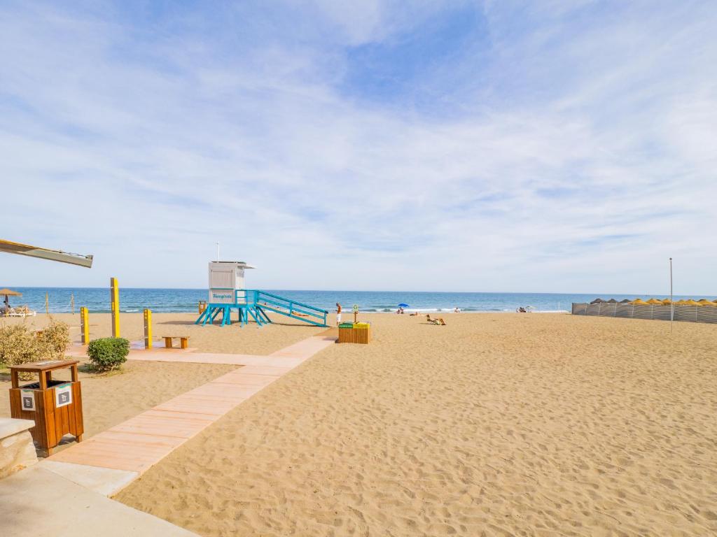 a sandy beach with a playground and the ocean at Cubo's Apartamento 2 Concha del Mar in Fuengirola