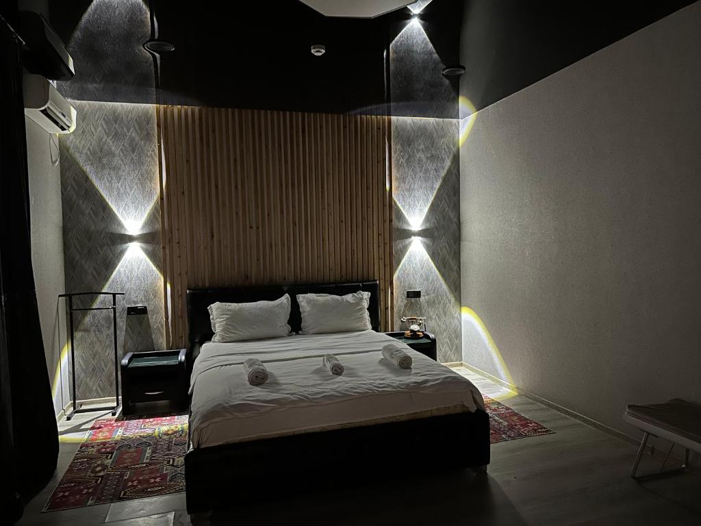 a bedroom with a bed with lights on the wall at Гостевой дом на Коктобе Люкс 4 in Almaty