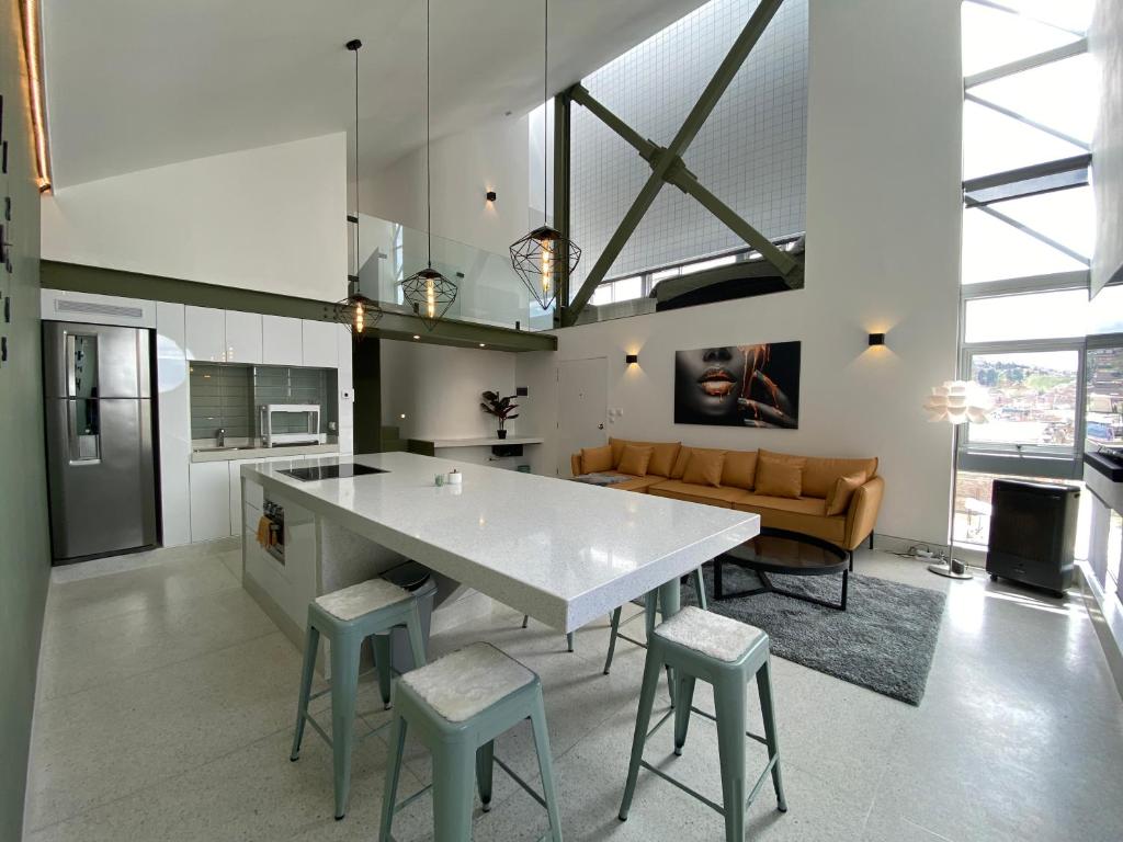a kitchen with a large white table and some chairs at Departamento duplex diseño exclusivo in Huancayo