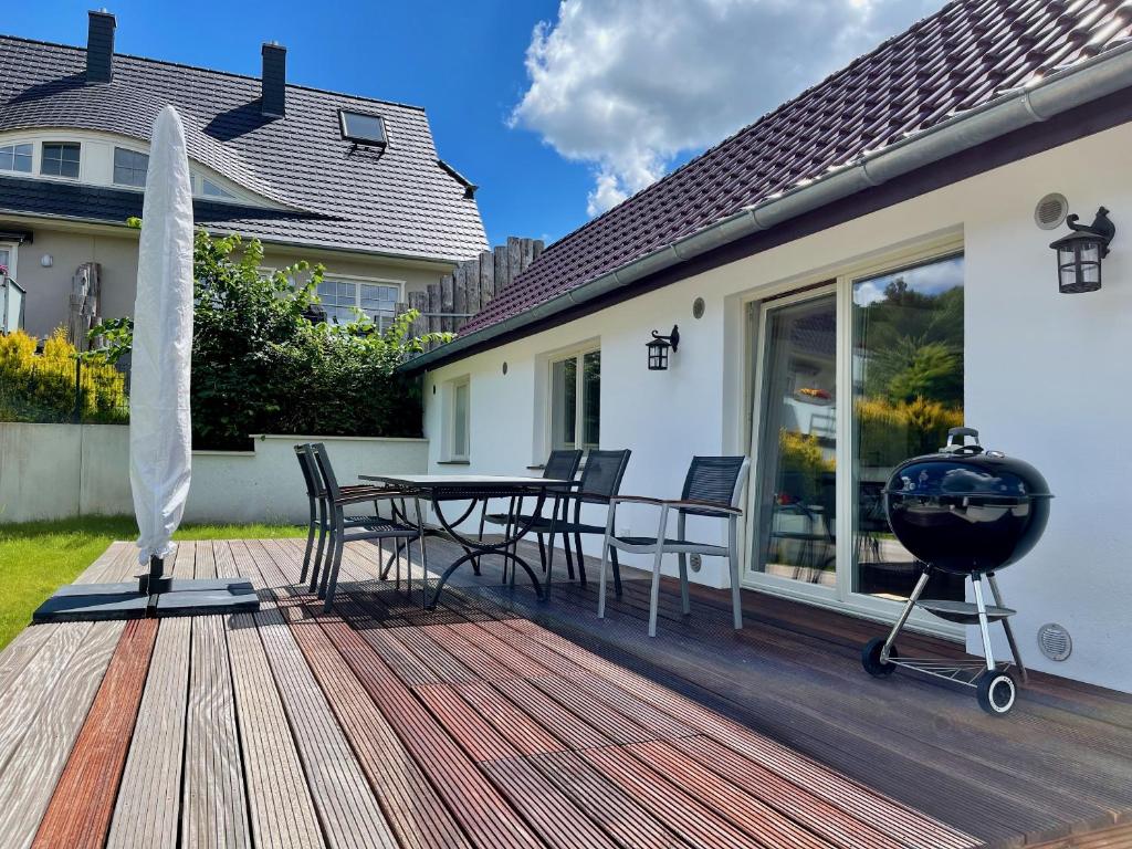 a wooden deck with a table and chairs on a house at Ferienhaus Altes Fischerhaus in Binz