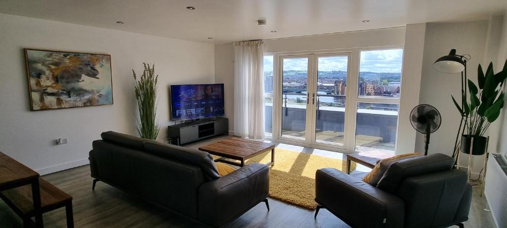 a living room with two couches and a large window at Room in City Centre Penthouse Apartment in Belfast