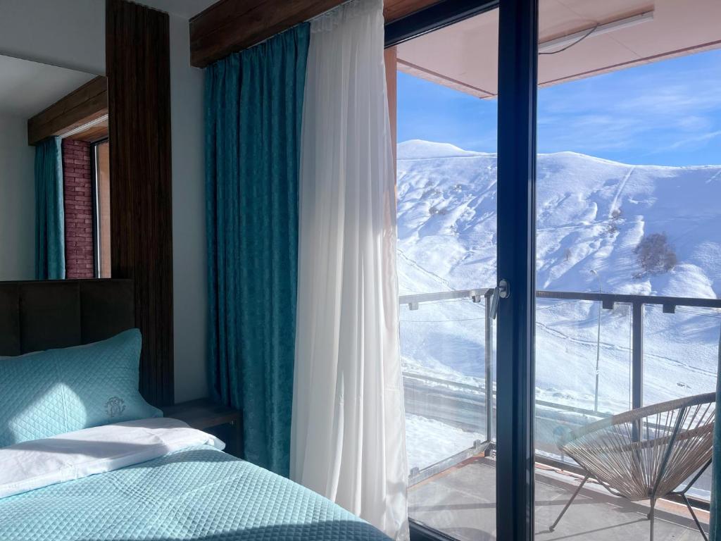 a bedroom with a view of a snow covered mountain at Luxury apartment with specticular views in Gudauri