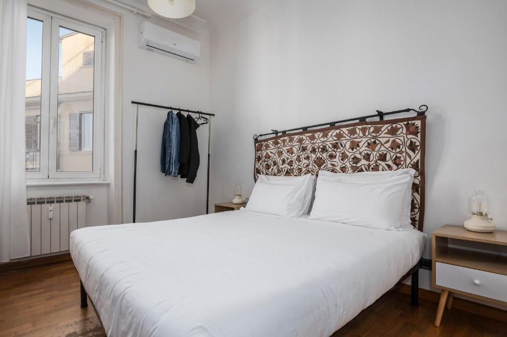 Un dormitorio con una gran cama blanca y una ventana en Belle Arti Zen Apartment, en Roma
