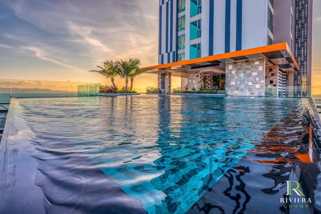a swimming pool in front of a building at luxury stay Monaco in Na Jomtien