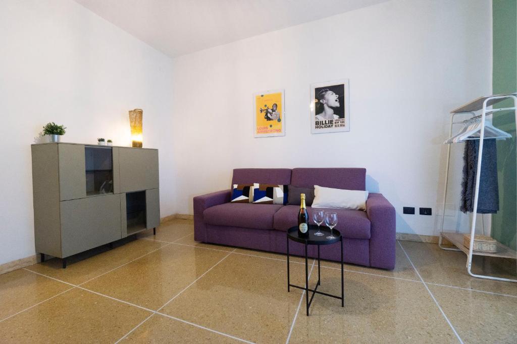 a living room with a purple couch and a tv at Realkasa Kharkov Apartment in Bologna