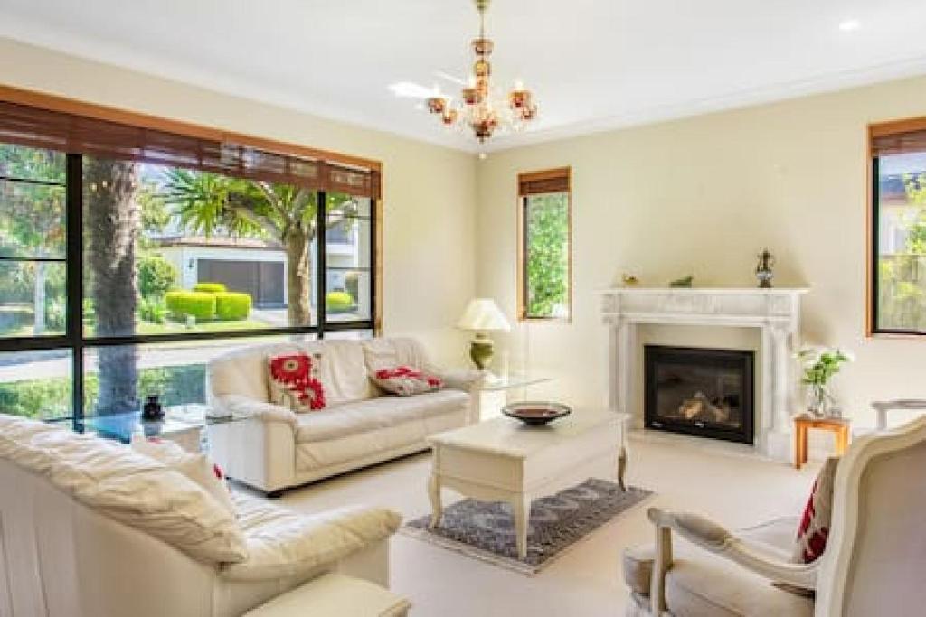 a living room with a couch and a fireplace at Northpark Getaway with patio area in Auckland