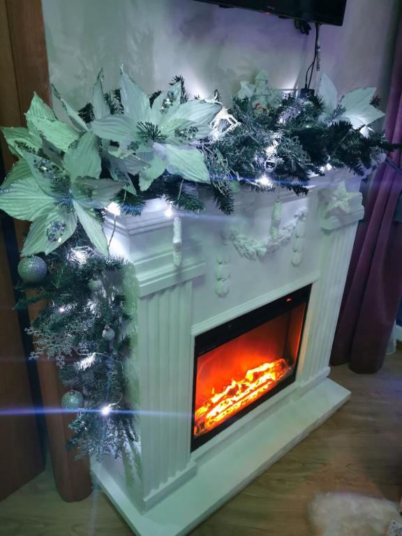 a fireplace with a christmasreath on top of it at APARTMAN 94 in Zlatibor