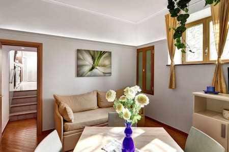 una sala de estar con un jarrón de flores sobre una mesa en Casa dellAccademia Apartment in Sorrento Centre, en Sorrento