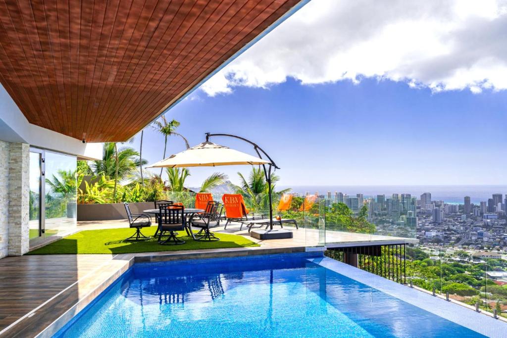 a house with a swimming pool and a view of the city at KBM Resorts: Skyridge Sweeping Ocean City Views in Honolulu