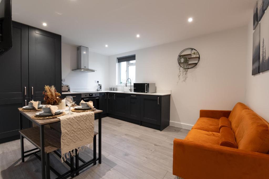 a kitchen and living room with a couch and a table at Modern, Stylish, cosy, Finchley London 3 Bed 2 bath Apartment with Free Parking in Whetstone