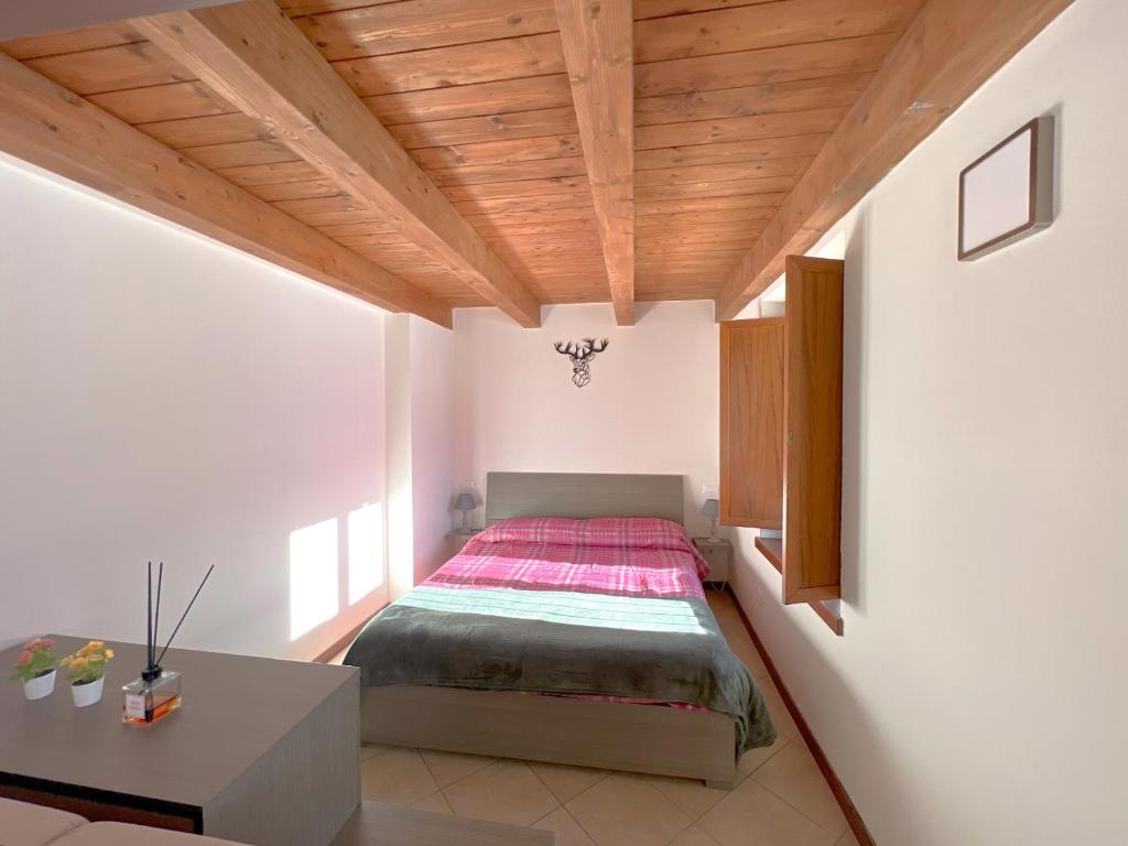 a bedroom with a bed and a wooden ceiling at Affittimoderni Ponte di Legno Ski - PDL23 in Ponte di Legno
