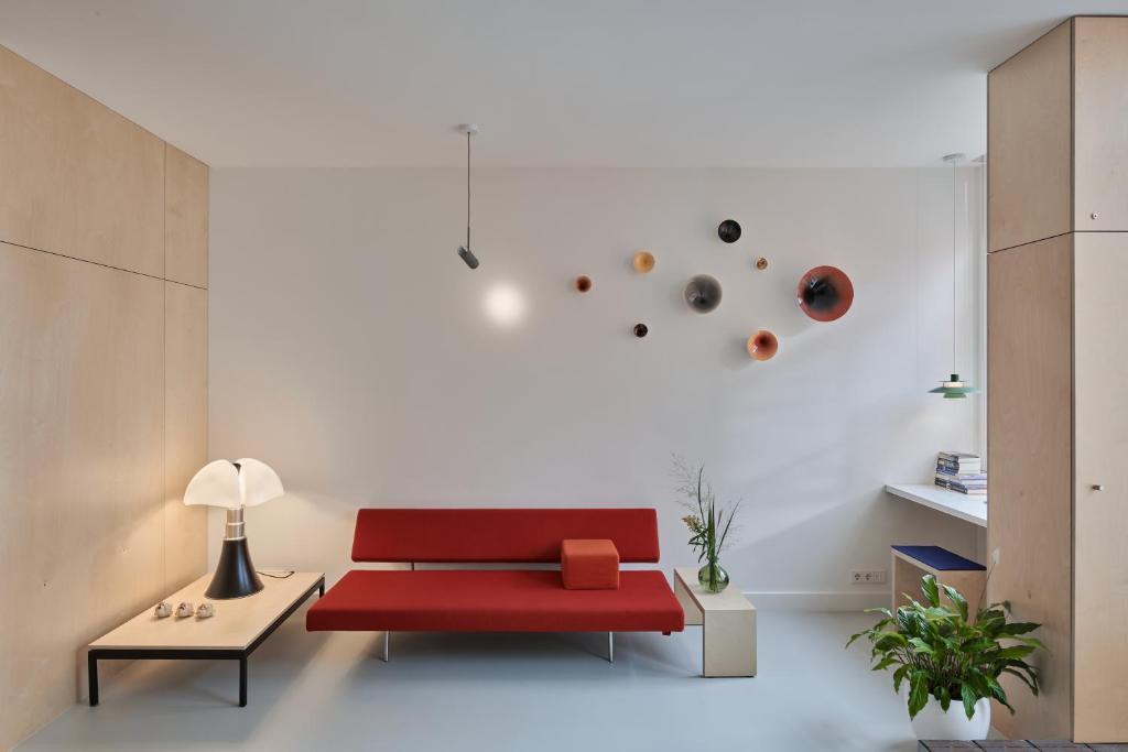 a living room with a red couch and a table at LE GARAGE Downtown serviced apartment in The Hague