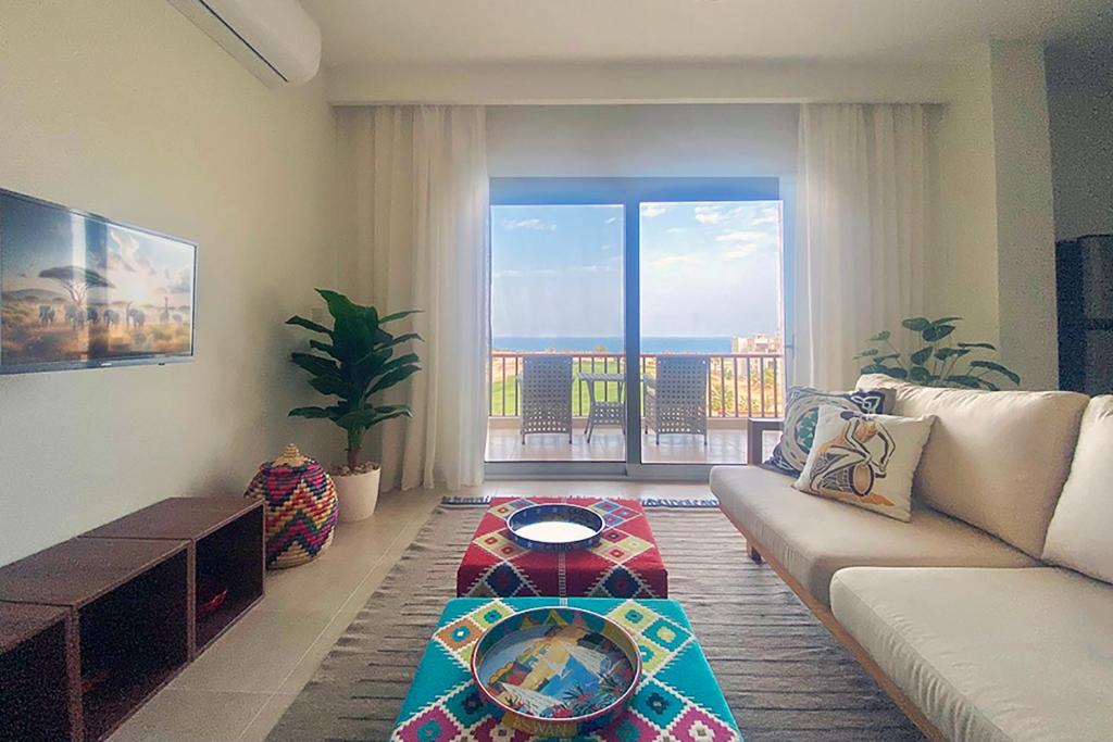 a living room with a couch and a large window at Soma Bay Sea View Penthouse in Hurghada