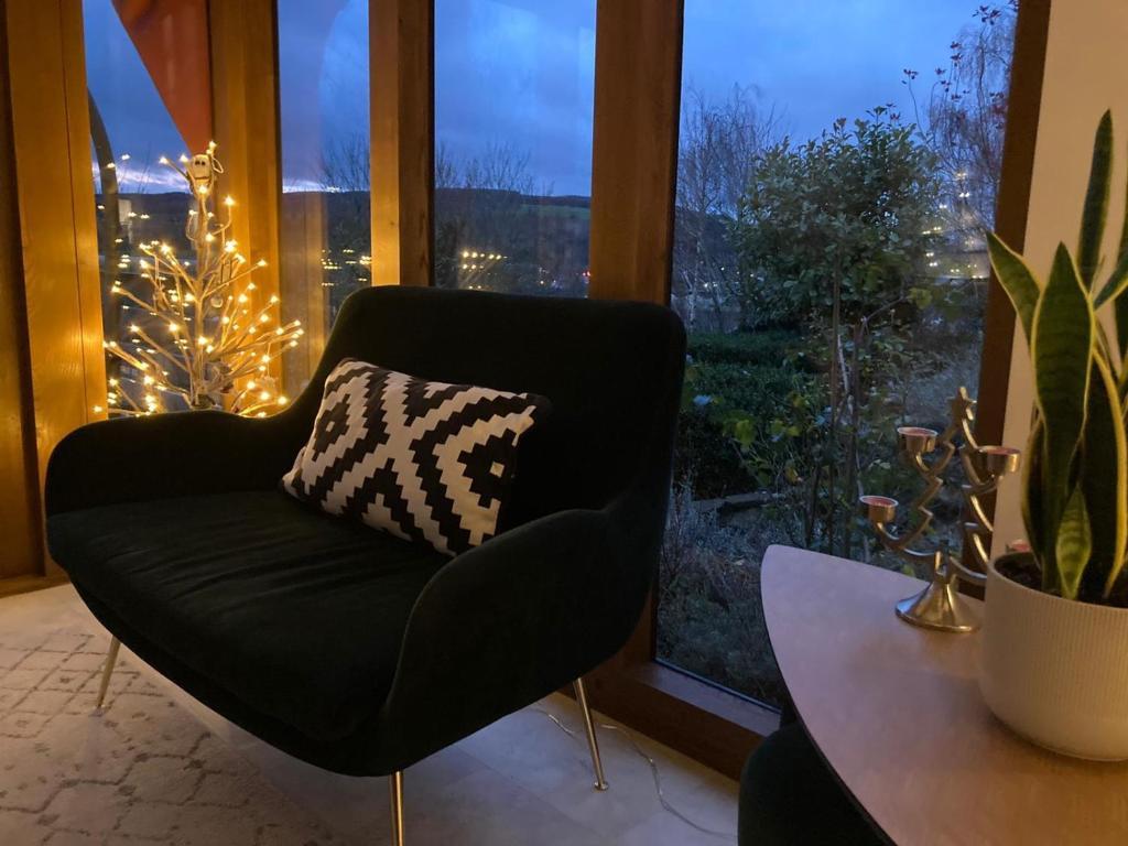 uma cadeira preta com uma almofada num quarto com uma janela em The Folly em Ludlow